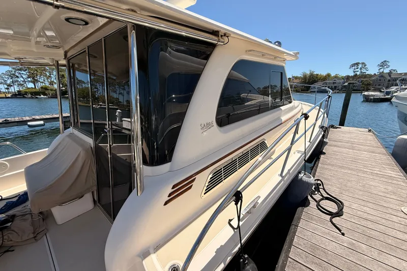 Slide: The Image of 2022 Sabre 38 Salon Express yacht docked at marina under clear blue sky. - 7