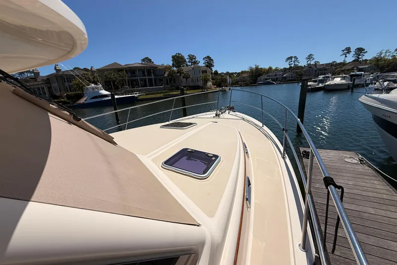 Slide: The Image of 2022 Sabre 38 Salon Express yacht docked at a marina under clear blue skies. - 8