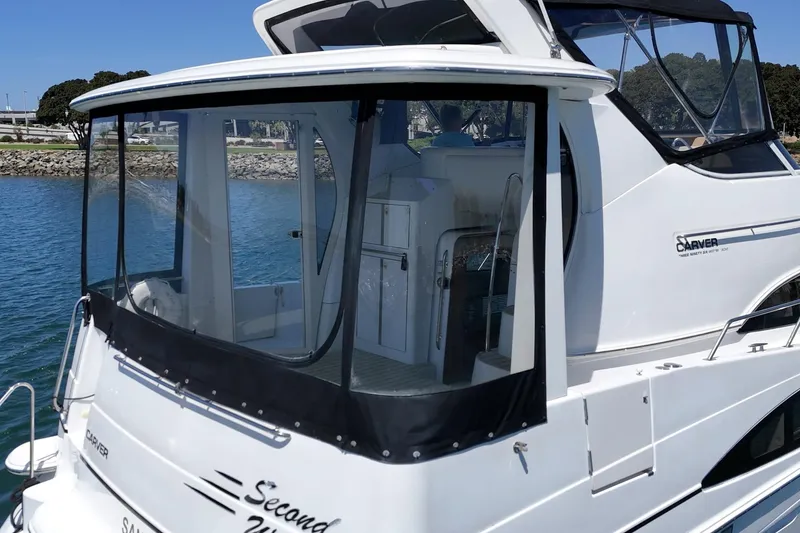 Slide: The Image of 2002 Carver 396 Motor Yacht docked, featuring enclosed deck and sleek design. - 14