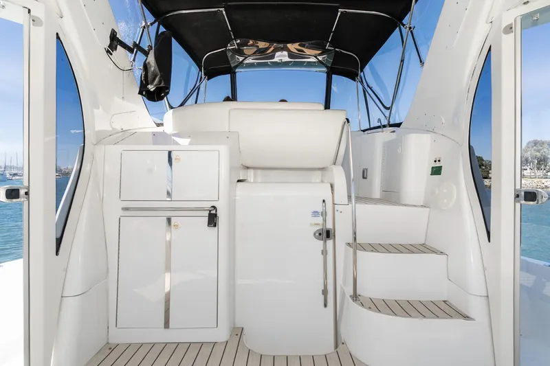 Slide: The Image of 2002 Carver 396 Motor Yacht interior with sleek white cabinetry and stairs, featuring a black canopy. - 17