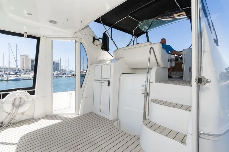 Slide: The Image of 2002 Carver 396 Motor Yacht interior with marina view, featuring steps and seating area. - 18