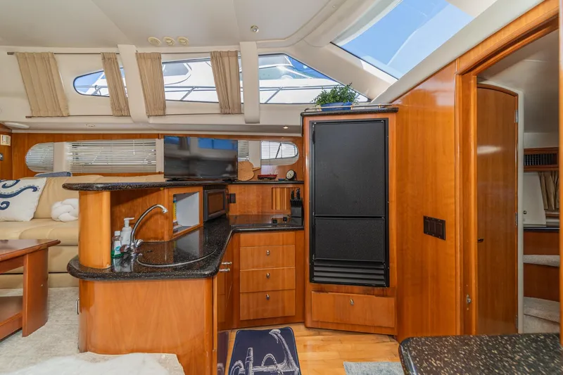 Slide: The Image of Interior of 2002 Carver 396 Motor Yacht with modern kitchen and seating area. - 29