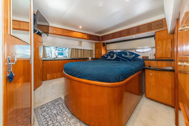 Slide: The Image of Luxurious 2002 Carver 396 Motor Yacht bedroom with elegant wood finishes and cozy bedding. - 31