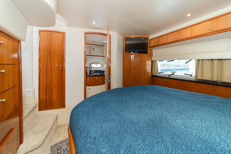 Slide: The Image of Luxurious interior of 2002 Carver 396 Motor Yacht with wood accents and cozy bedding. - 33