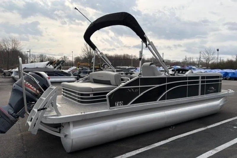 Slide: The Image of 2021 Bennington 22 SSBX pontoon boat with canopy, parked outdoors. - 10