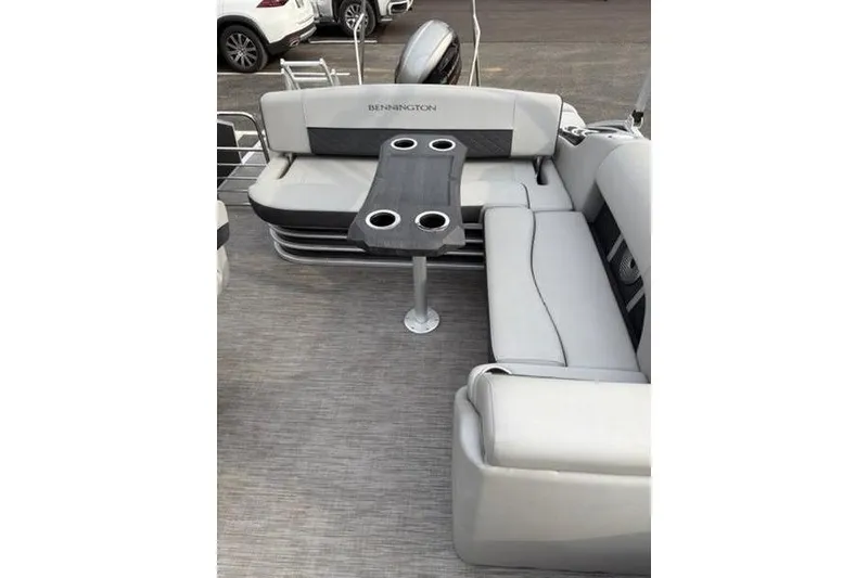 Slide: The Image of 2021 Bennington 22 SSBX pontoon boat interior with gray seating and table with cup holders. - 20