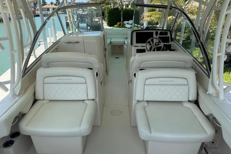 Slide: The Image of 2022 Grady-White Freedom 285 boat cruising on turquoise waters under a cloudy sky. - 11