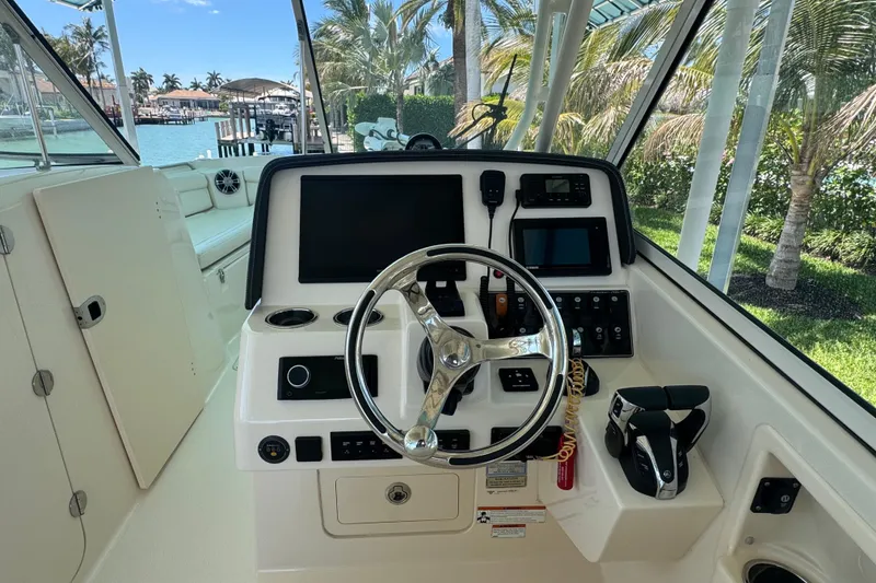 Slide: The Image of 2022 Grady-White Freedom 285 boat cruising on clear blue water under a partly cloudy sky. - 17