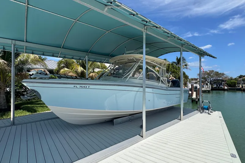 Slide: The Image of 2022 Grady-White Freedom 285 boat cruising on clear blue water under a partly cloudy sky. - 2