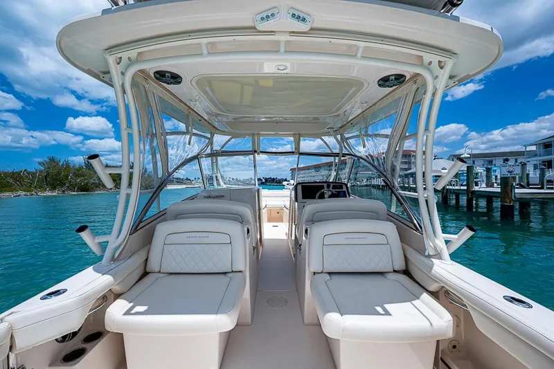 Slide: The Image of 2022 Grady-White Freedom 285 boat interior with luxurious seating, docked by clear blue water. - 26