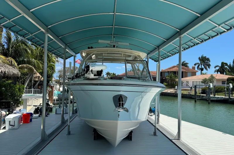 Slide: The Image of 2022 Grady-White Freedom 285 boat cruising on clear blue water under a partly cloudy sky. - 3