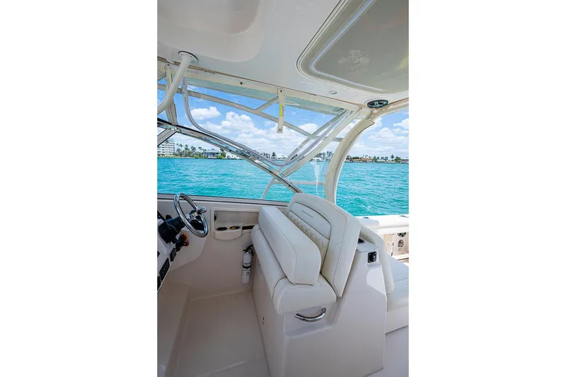 Slide: The Image of 2022 Grady-White Freedom 285 boat interior with steering wheel and ocean view. - 32