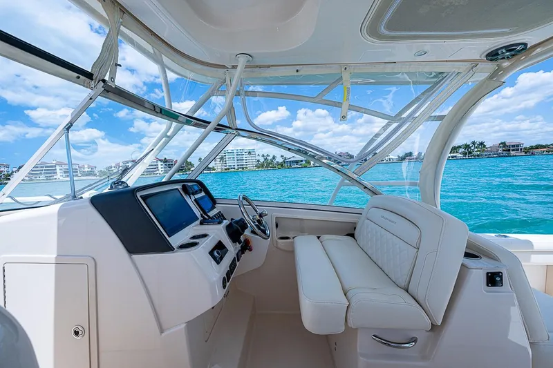 Slide: The Image of 2022 Grady-White Freedom 285 boat interior with helm, luxurious seating, and ocean view. - 33