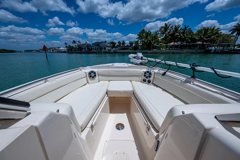 Slide: The Image of 2022 Grady-White Freedom 285 boat interior with spacious seating, set against a scenic waterfront. - 40