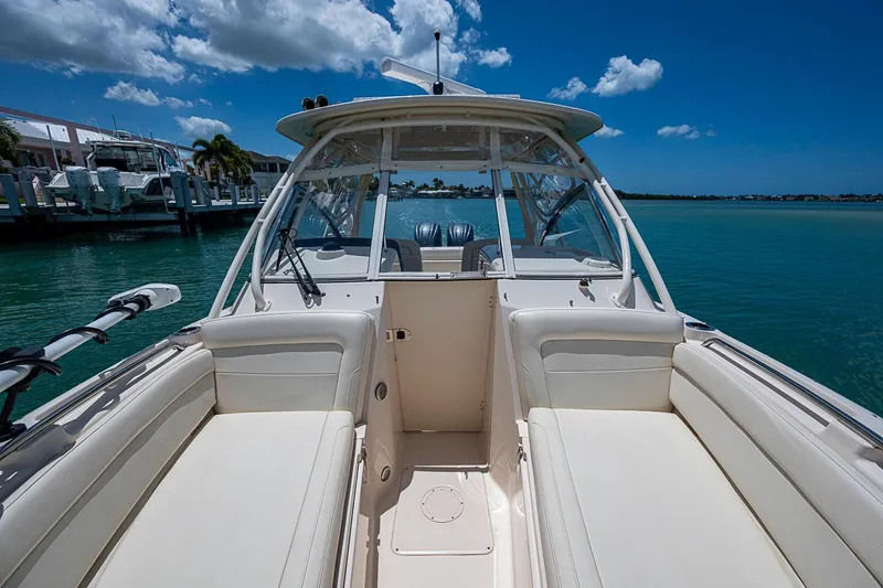 Slide: The Image of 2022 Grady-White Freedom 285 boat interior with seating, docked by clear blue water. - 41