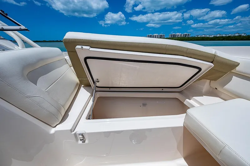 Slide: The Image of 2022 Grady-White Freedom 285 boat with open storage compartment under blue sky. - 44