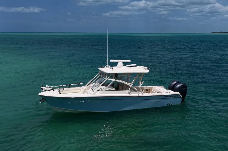 Slide: The Image of 2022 Grady-White Freedom 285 boat on clear blue ocean water under a partly cloudy sky. - 49