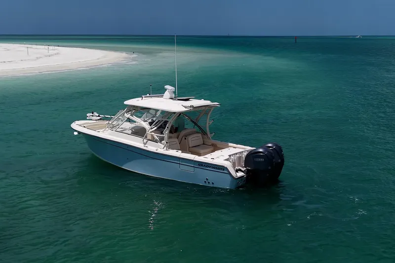 Slide: The Image of 2022 Grady-White Freedom 285 boat anchored in clear turquoise waters near a sandy beach. - 50