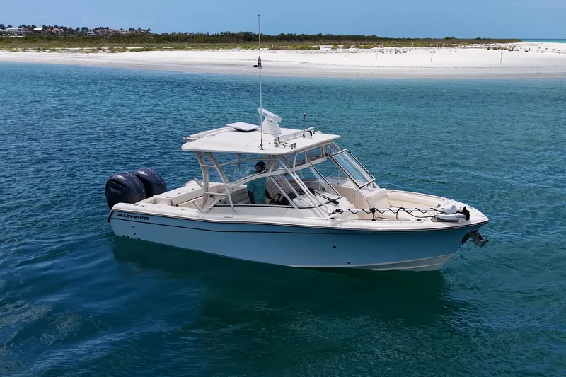 Slide: The Image of 2022 Grady-White Freedom 285 boat on clear blue water near sandy beach. - 59