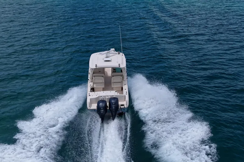 Slide: The Image of 2022 Grady-White Freedom 285 boat cruising on open water, rear view. - 60