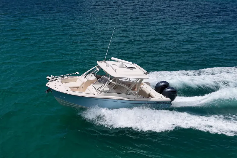 Slide: The Image of 2022 Grady-White Freedom 285 boat cruising on clear blue water. - 62