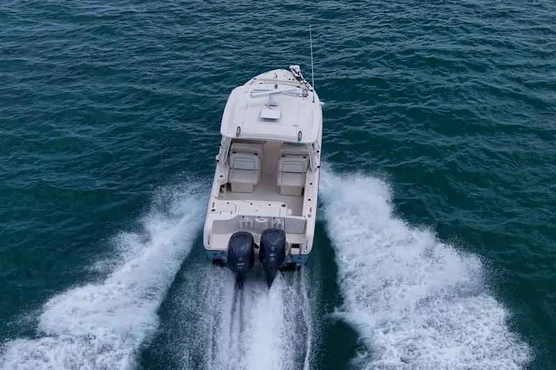 Slide: The Image of 2022 Grady-White Freedom 285 boat cruising on open water, rear view. - 75