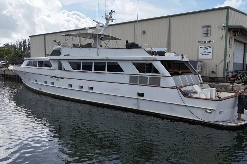 Slide: The Image of 1990 Denison 109 yacht docked near industrial building. - 15