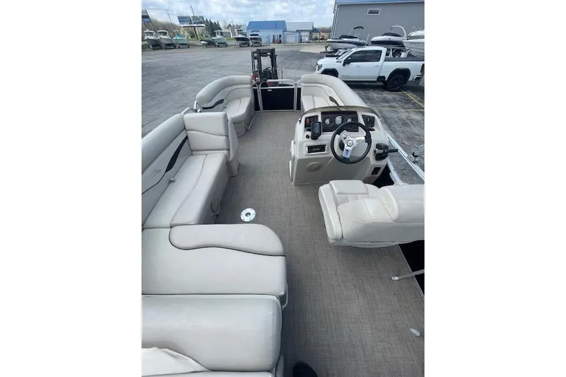 Slide: The Image of 2015 Bennington S20 pontoon boat interior with beige seating and steering console. - 3