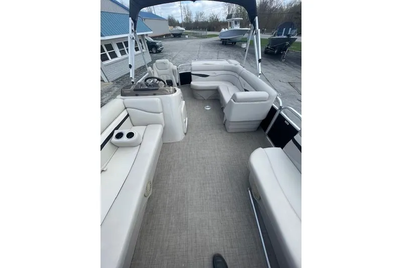 Slide: The Image of 2015 Bennington S20 pontoon boat interior with beige seating and steering console. - 5
