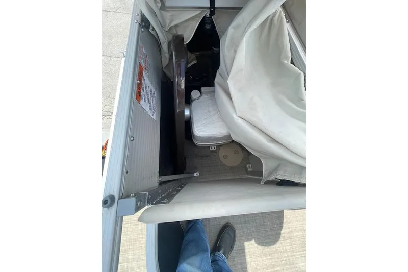 Slide: The Image of 2015 Bennington S20 boat interior with covered seating and storage area. - 7