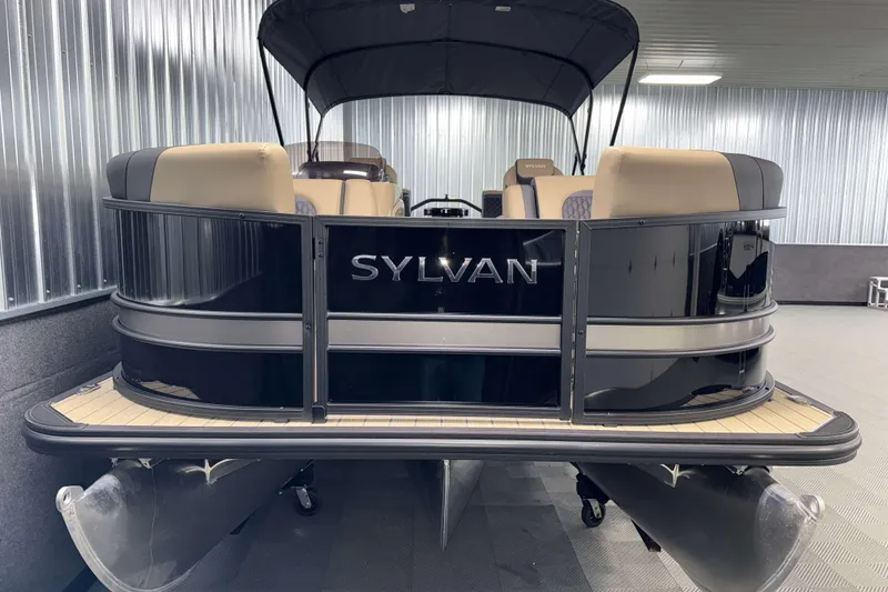 Slide: The Image of 2026 Sylvan L1 LZ pontoon boat in showroom, featuring sleek black design and beige seating. - 24