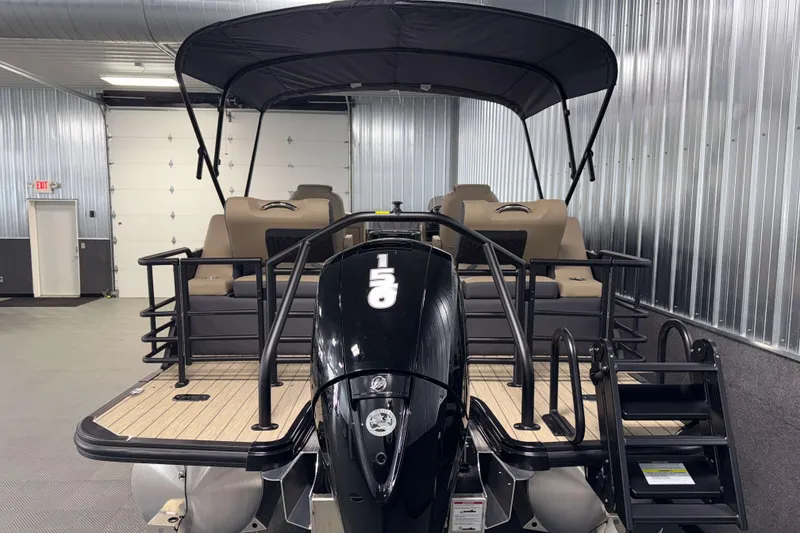 Slide: The Image of 2026 Sylvan L1 LZ pontoon boat with canopy in a metal-walled showroom. - 30