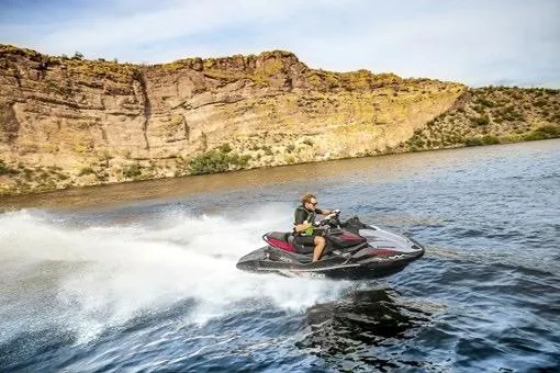 Slide: The Image of Man riding 2026 Kawasaki ULTRA 160 LX-S jet ski on a scenic lake. - 4