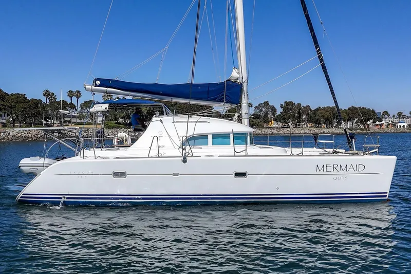 Slide: The Image of 2004 Lagoon 380 catamaran sailing on calm waters under a clear blue sky. - 10