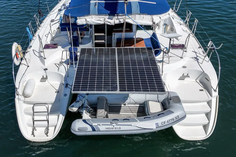 Slide: The Image of Lagoon 380 catamaran with solar panels and dinghy, 2004 model, on water. - 15