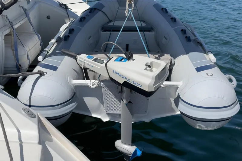 Slide: The Image of Inflatable boat with electric motor, docked beside a 2004 Lagoon 380 catamaran. - 19