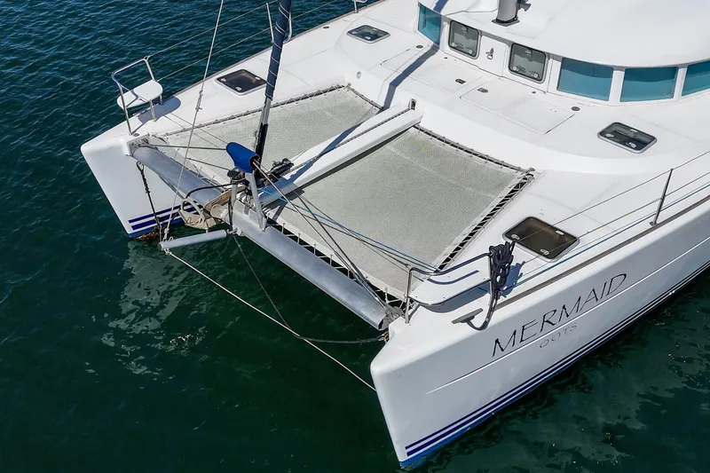 Slide: The Image of Lagoon 380 catamaran, 2004 model, named "Mermaid," on calm blue water. - 20