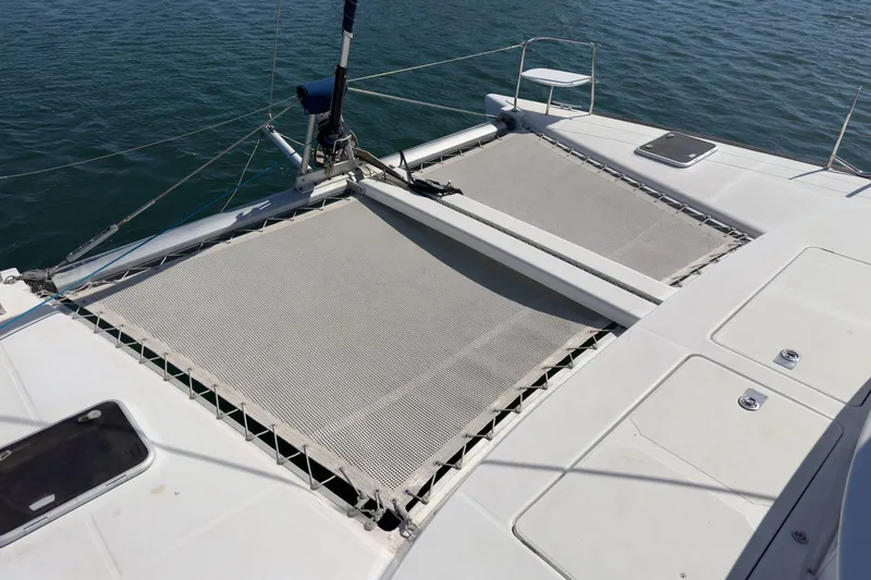 Slide: The Image of 2004 Lagoon 380 catamaran deck with netting over water. - 21