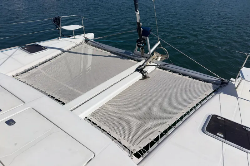 Slide: The Image of Catamaran Lagoon 380 (2004) with netted deck over calm water. - 23