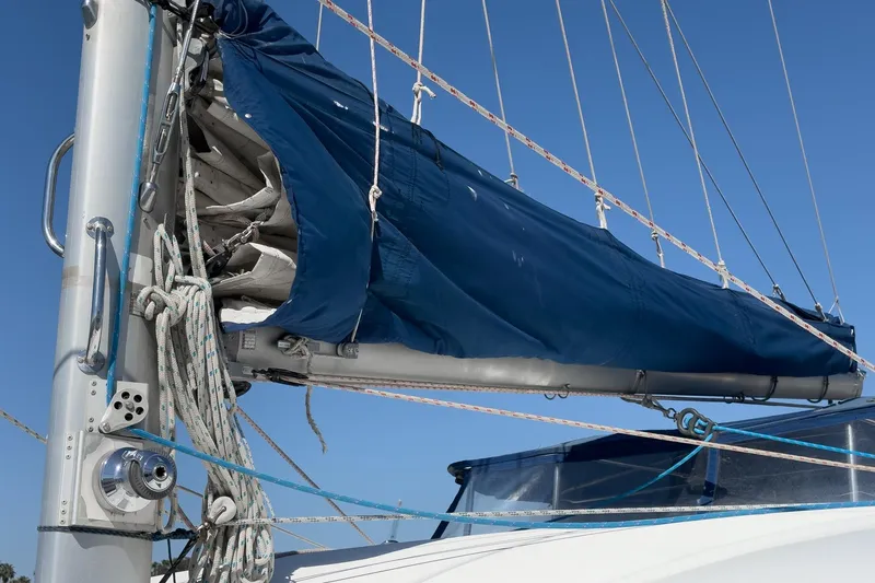Slide: The Image of Sail of a 2004 Lagoon 380 catamaran with blue cover and rigging. - 28