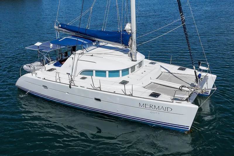 Slide: The Image of 2004 Lagoon 380 catamaran named "Mermaid" sailing on calm blue waters. - 3