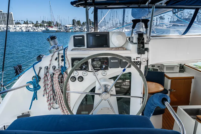 Slide: The Image of Helm of 2004 Lagoon 380 catamaran with navigation equipment and marina view. - 36
