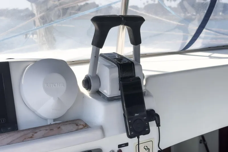 Slide: The Image of Throttle controls and compass on a 2004 Lagoon 380 catamaran cockpit. - 39