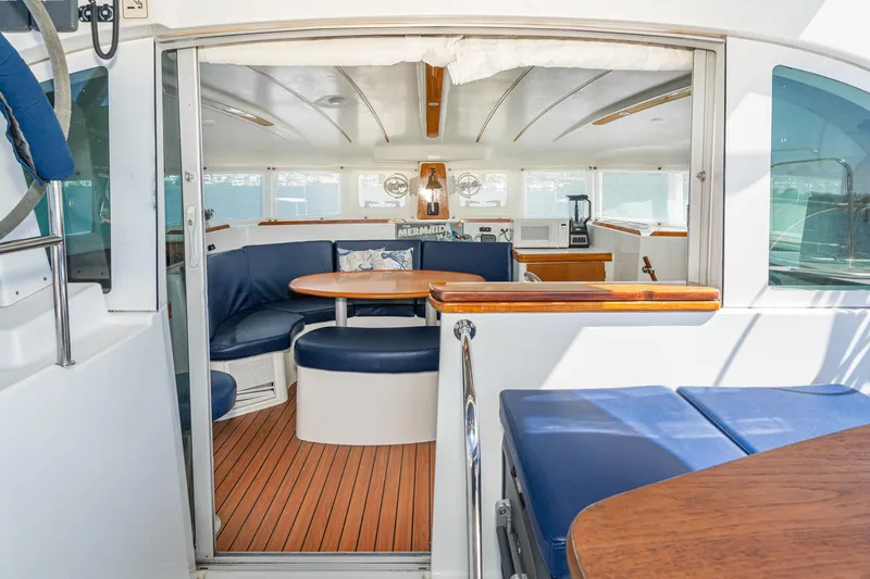 Slide: The Image of Interior of 2004 Lagoon 380 catamaran with blue seating and wooden accents. - 43