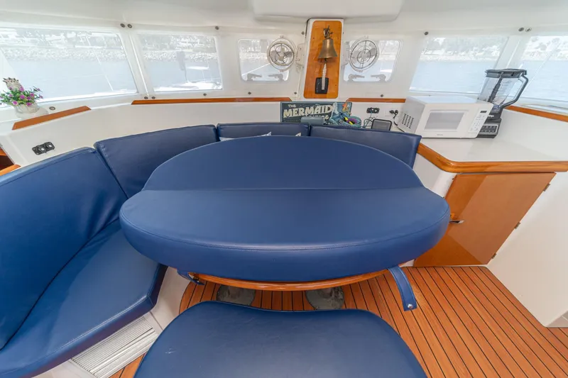 Slide: The Image of Interior of 2004 Lagoon 380 catamaran with blue seating, wooden flooring, and kitchen appliances. - 46