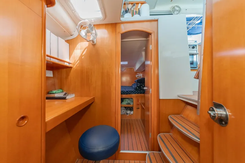 Slide: The Image of Interior of 2004 Lagoon 380 catamaran with wooden finish, desk, and cozy cabin space. - 55