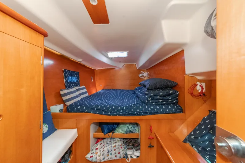 Slide: The Image of Cozy cabin interior of 2004 Lagoon 380 catamaran with wooden finish and nautical bedding. - 56