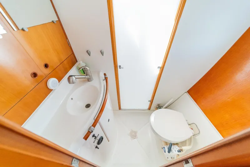 Slide: The Image of Compact bathroom in a 2004 Lagoon 380 catamaran, featuring a sink and toilet. - 63
