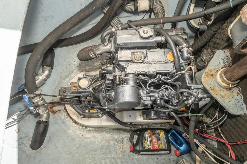 Slide: The Image of Engine compartment of a 2004 Lagoon 380 catamaran, featuring hoses and oil containers. - 74