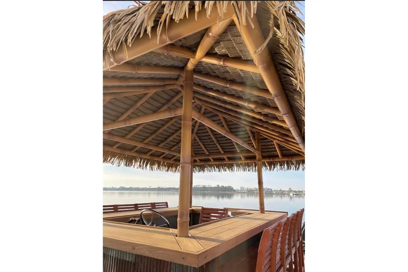 Slide: The Image of Tiki hut boat with thatched roof on a serene lake, Big Hut 26, 2023 model. - 4